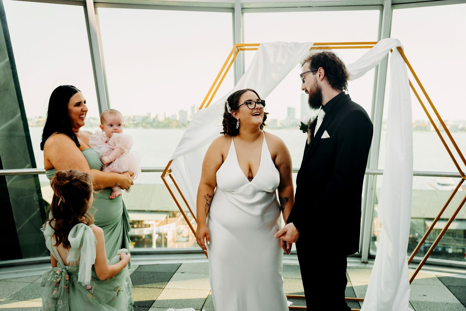 Romantic couple in formal attire shares intimate moments during a sunset photoshoot on a rooftop terrace.