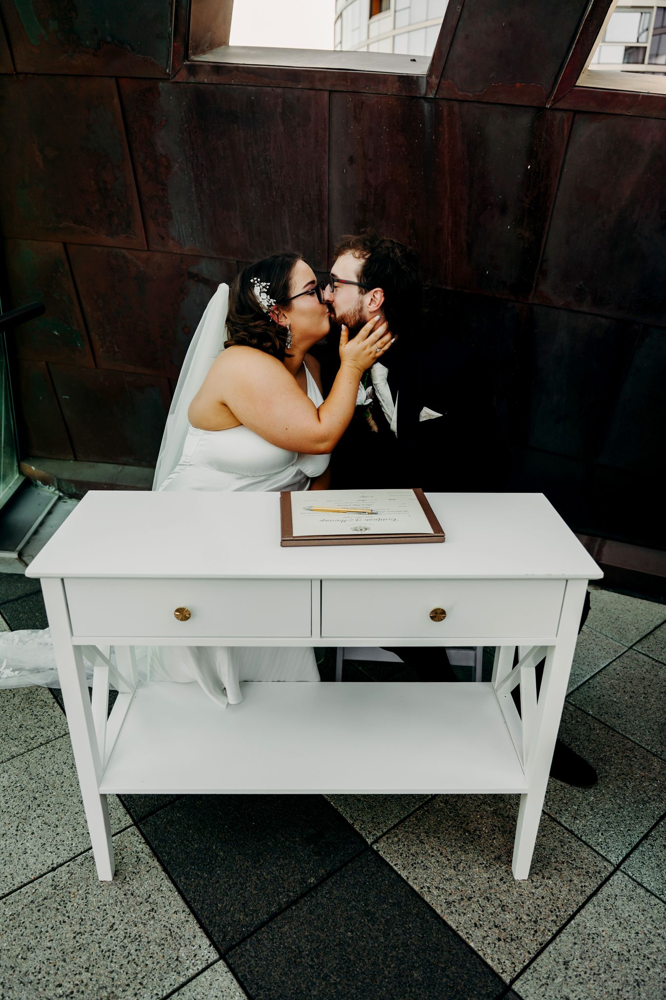A series of five wedding photos showing a couple signing their marriage documents at a white desk.