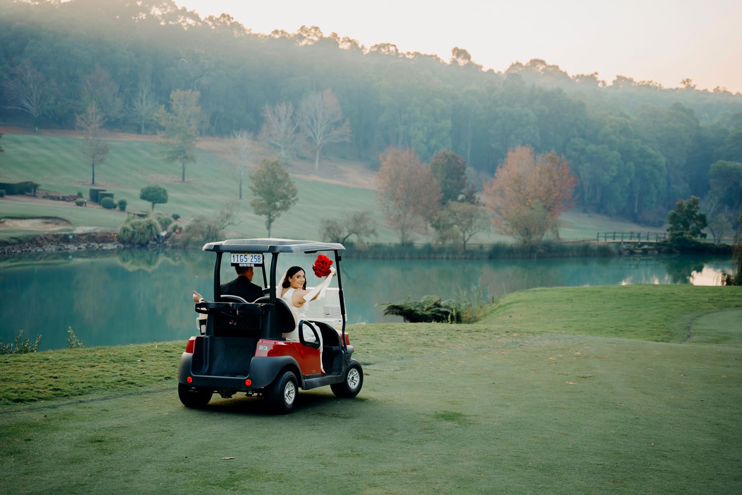 A red golf cart towing equipment travels across multiple frames of a foggy golf course landscape at dawn.
