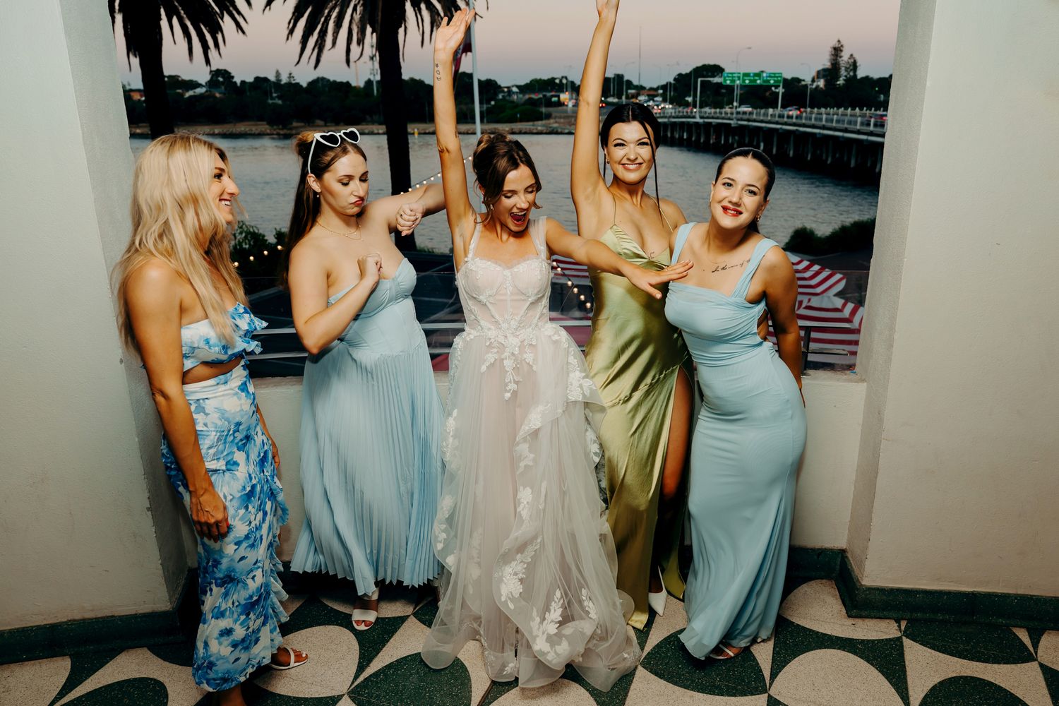 Group of bridesmaids in light blue dresses react with excitement in progression of candid photos.