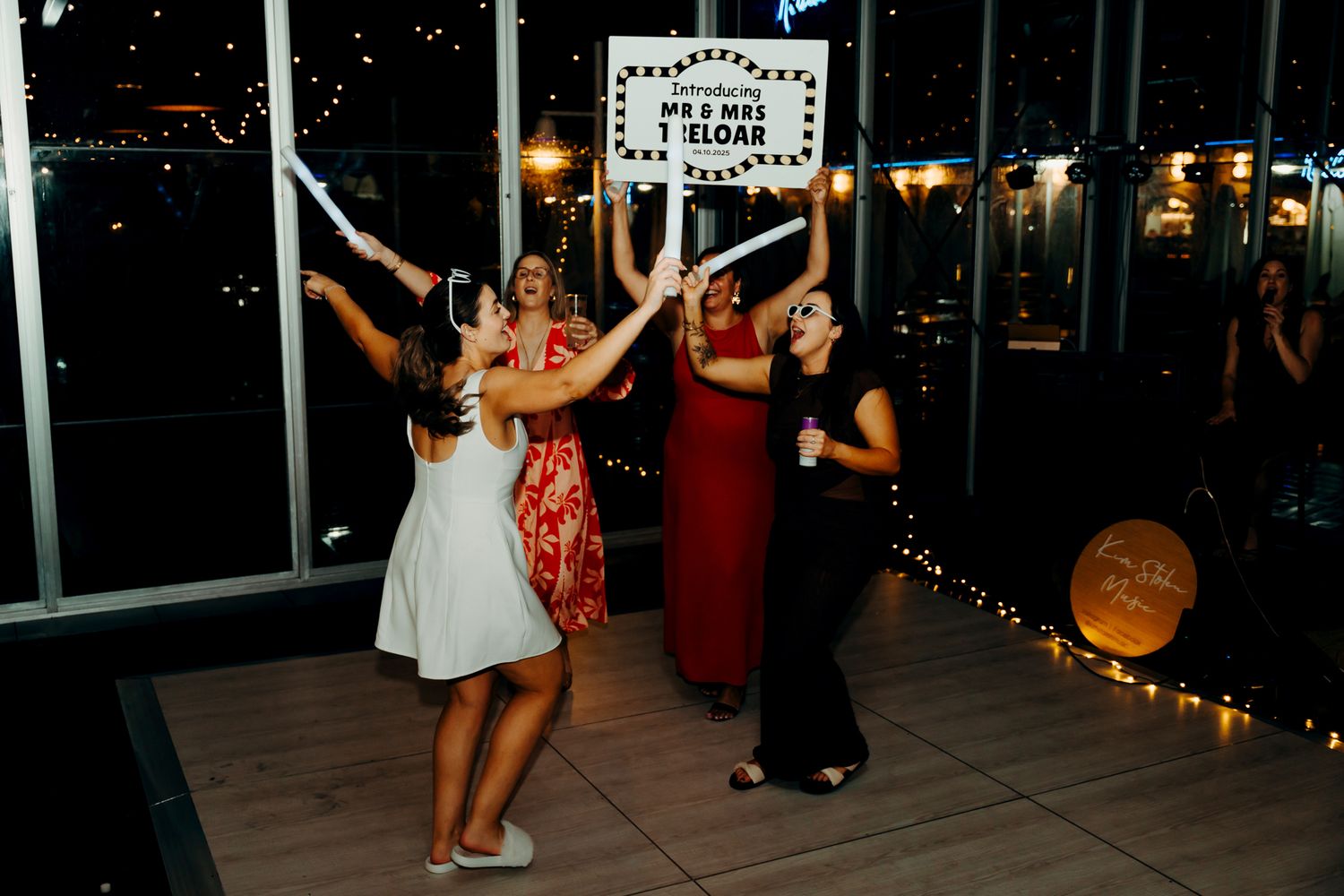 Nighttime wedding celebration with string lights and dancing guests.