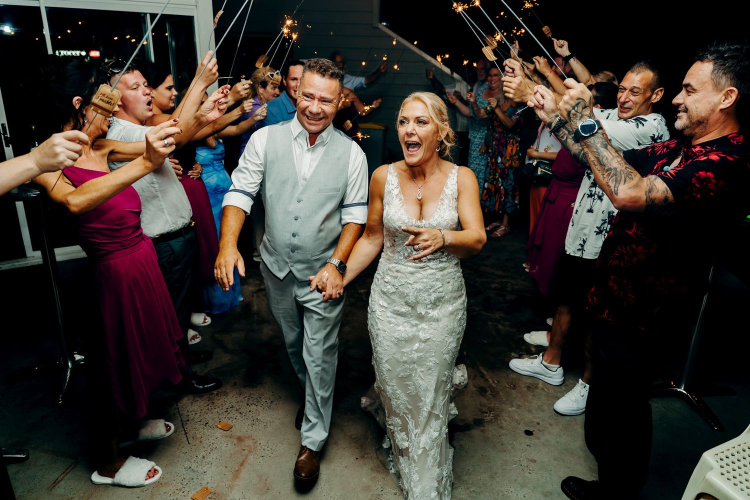 Wedding party and guests form a dance line on the reception floor as they celebrate with enthusiasm.