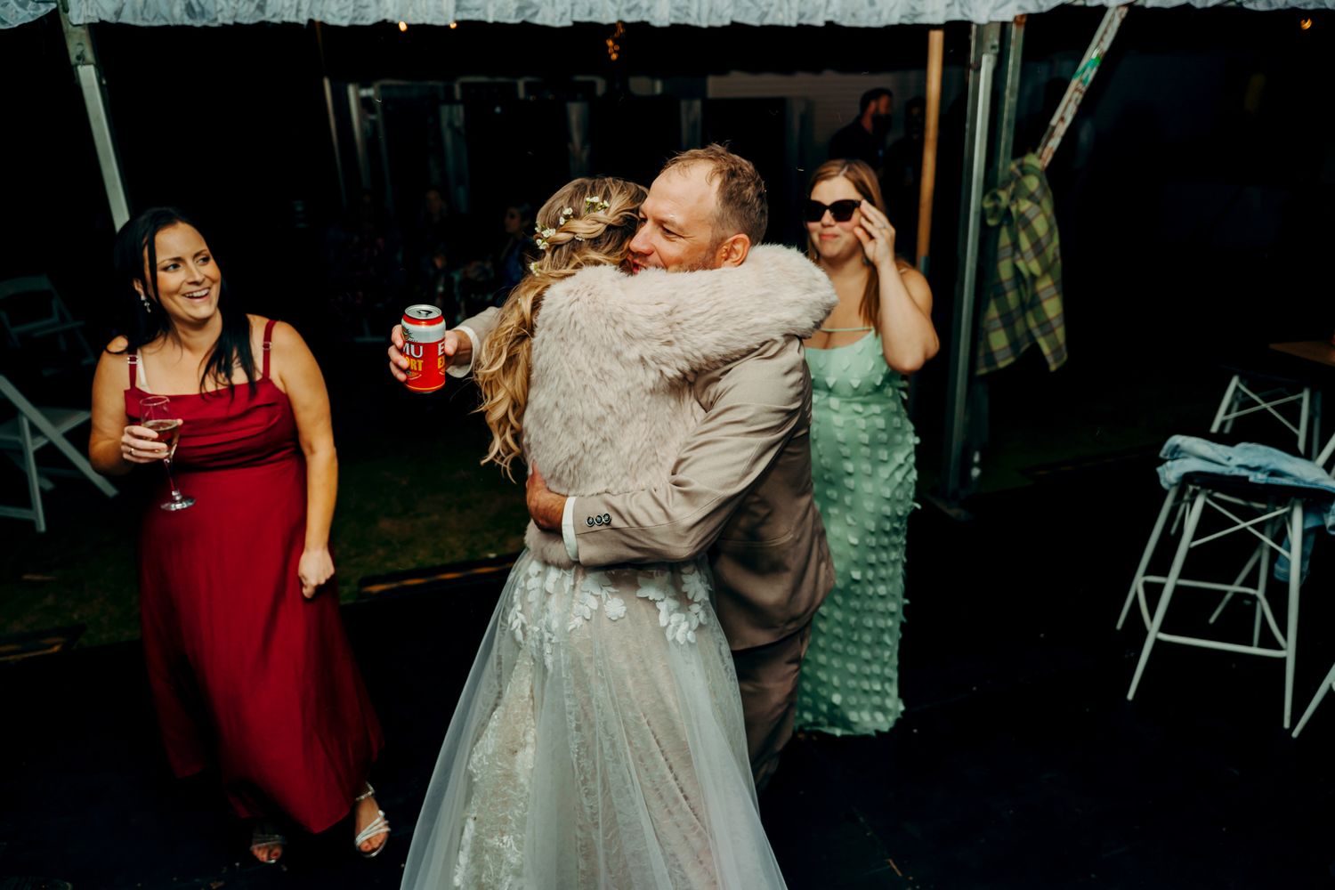 Wedding guests celebrate on a dance floor during an evening reception.