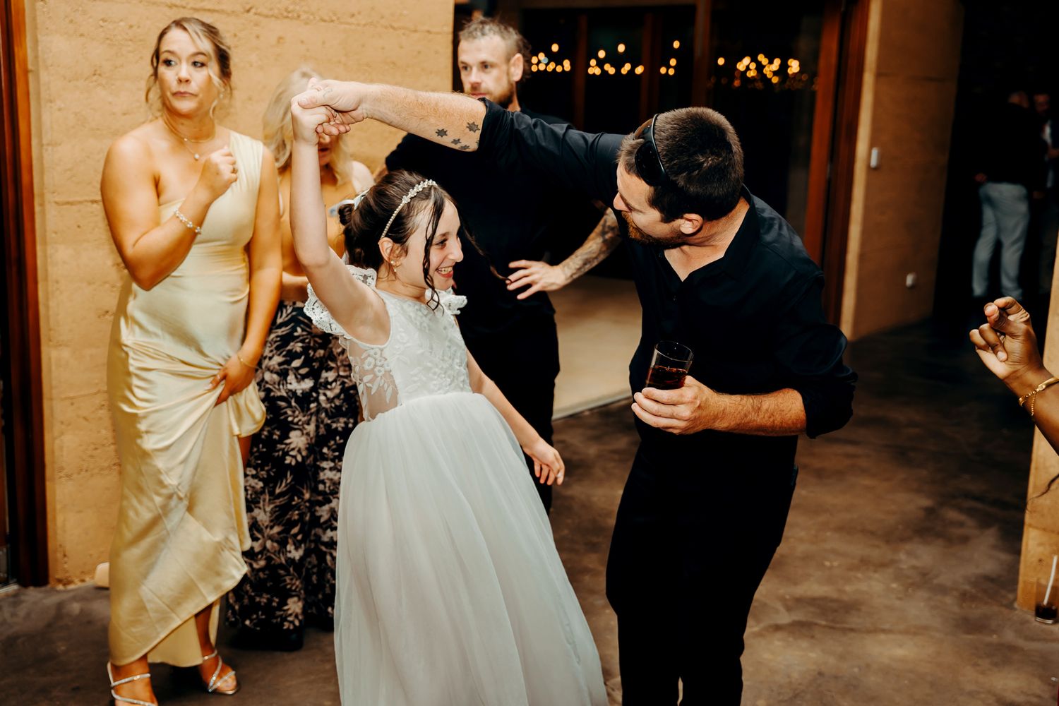 Bride and groom share their first dance together at an elegant wedding reception surrounded by guests.