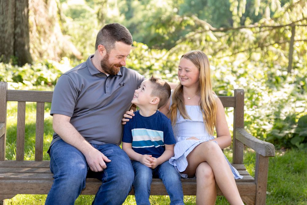 Father with children talking on a bench