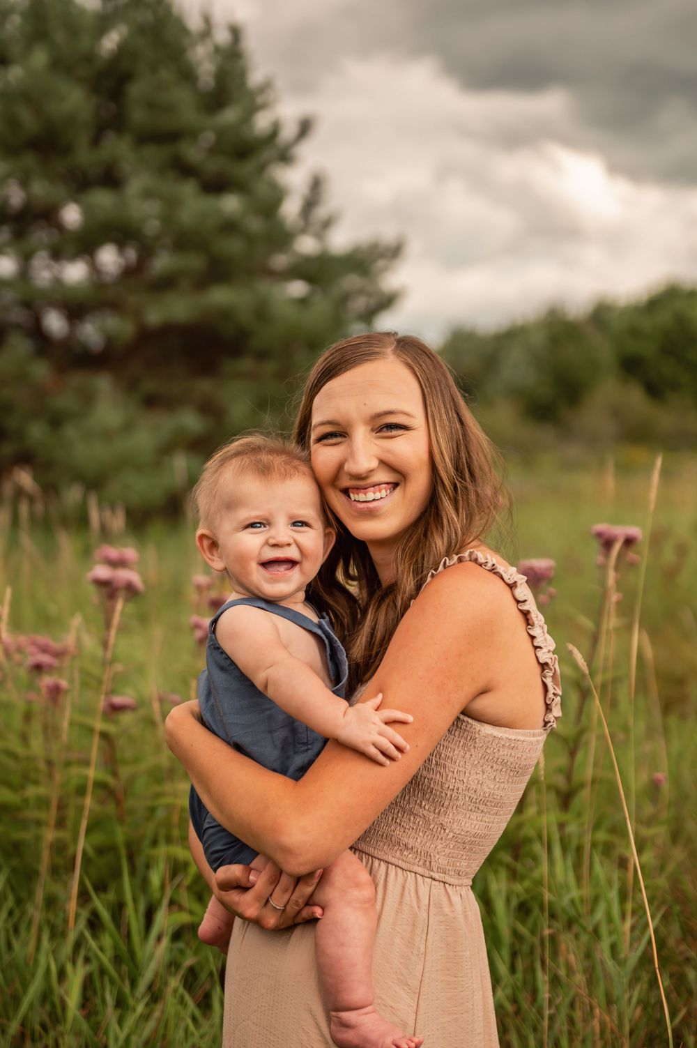 Heartwarming outdoor portrait of parent and child embracing in a summer meadow.