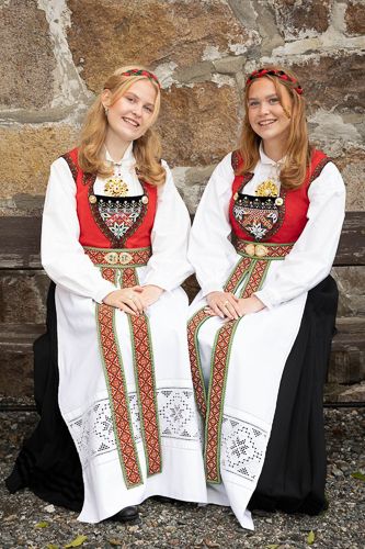 Two people wearing traditional Norwegian folk costumes with ornate embroidered details pose together in a series of photos.