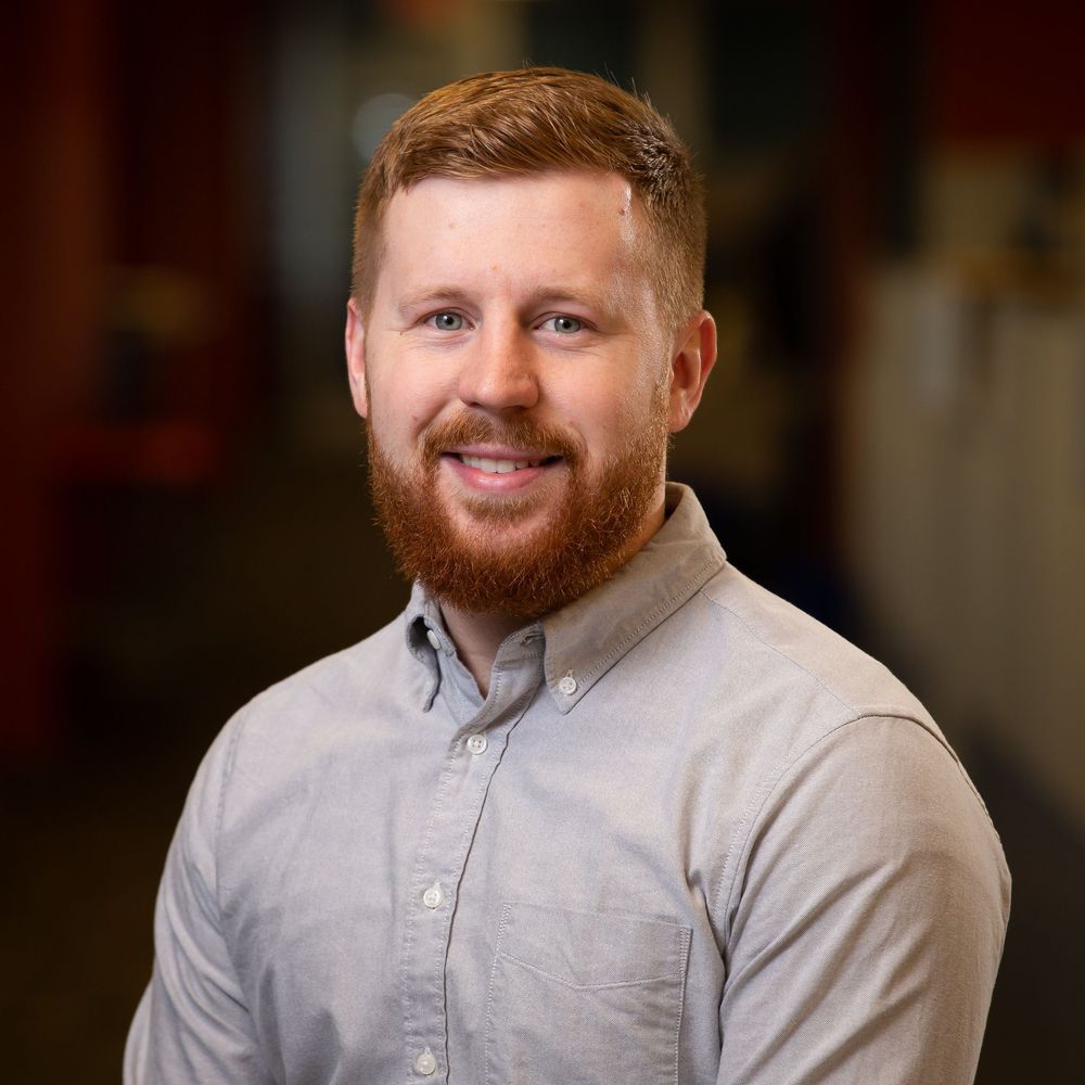 Casual business portrait of a male professional sitting in a modern workspace