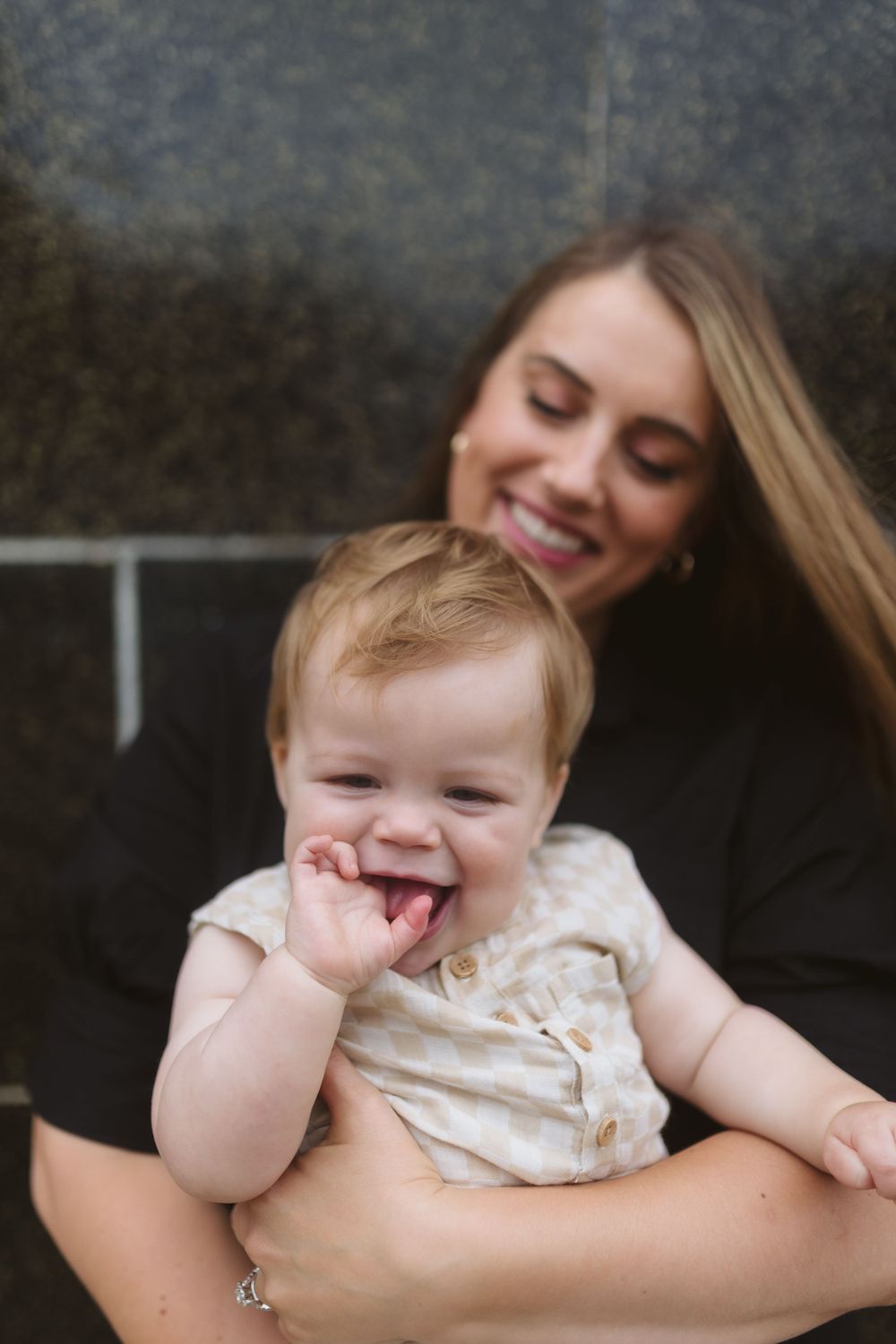 Sweet moment captured with baby making playful expression while being held.