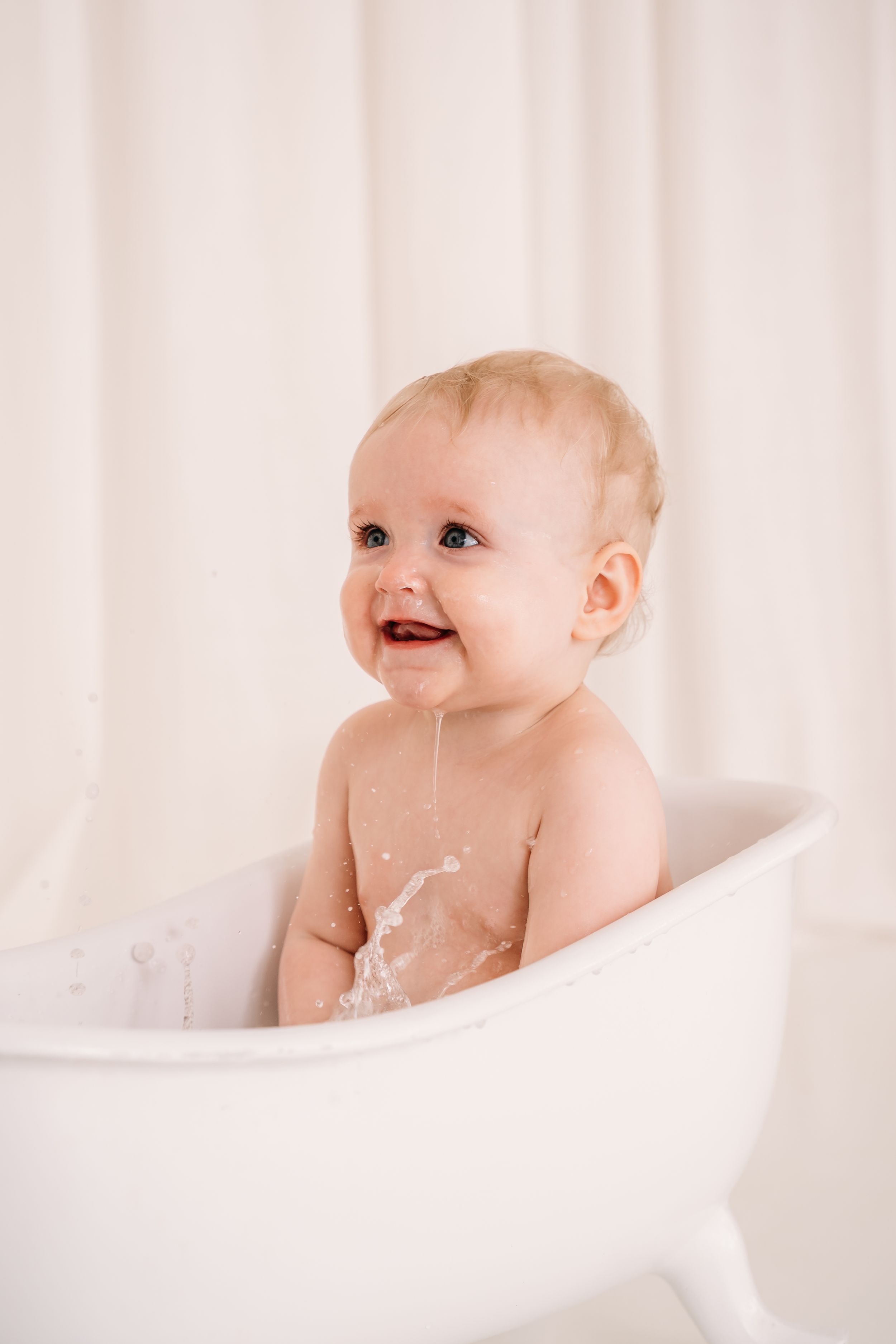 Baby in badje na cake smash fotoshoot voor eerste verjaardag in daglichtstudio in Edegem