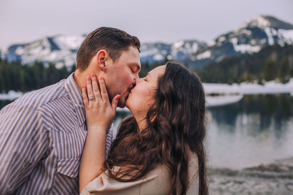 Romantic winter engagement photos with snow-capped mountains in the background. Spokane Liberty Lake Photographer Family Photographer