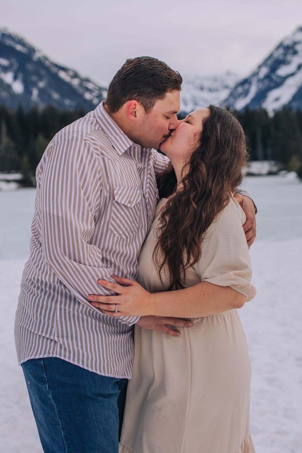 Intimate winter engagement session in front of snow-covered mountain range. Spokane Liberty Lake Photographer Family Photographer