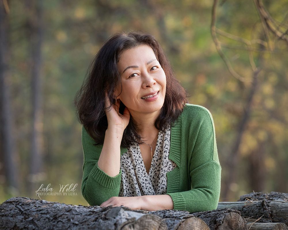 outdoor personal branding portrait of Asian woman in green sweater by Spokane headshot photographer in Post Falls Luba Wold