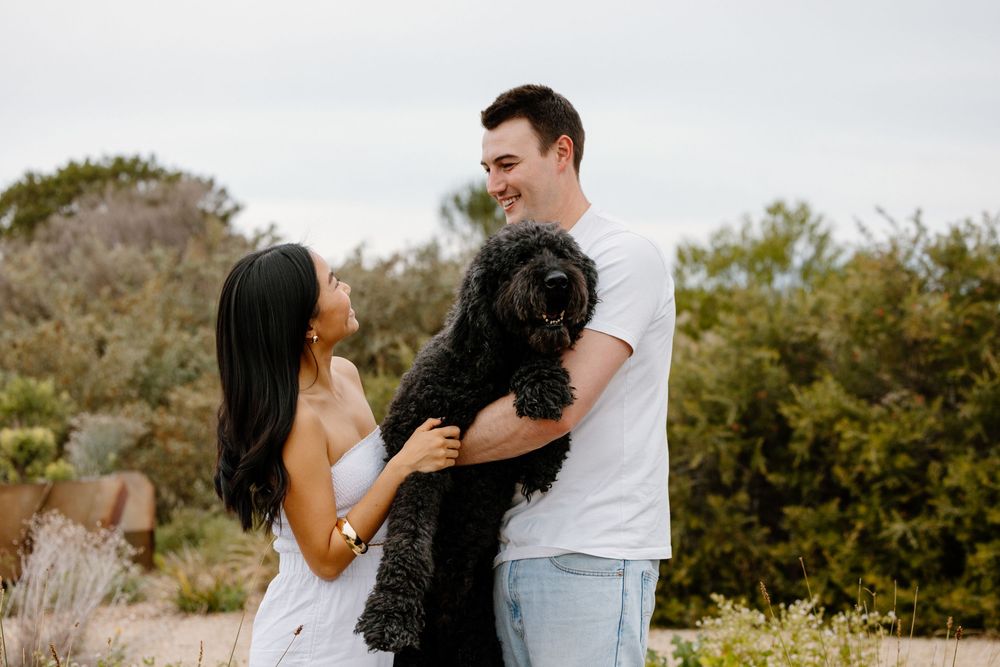 A couple shares tender moments together in a desert landscape setting during a romantic photoshoot at sunset.