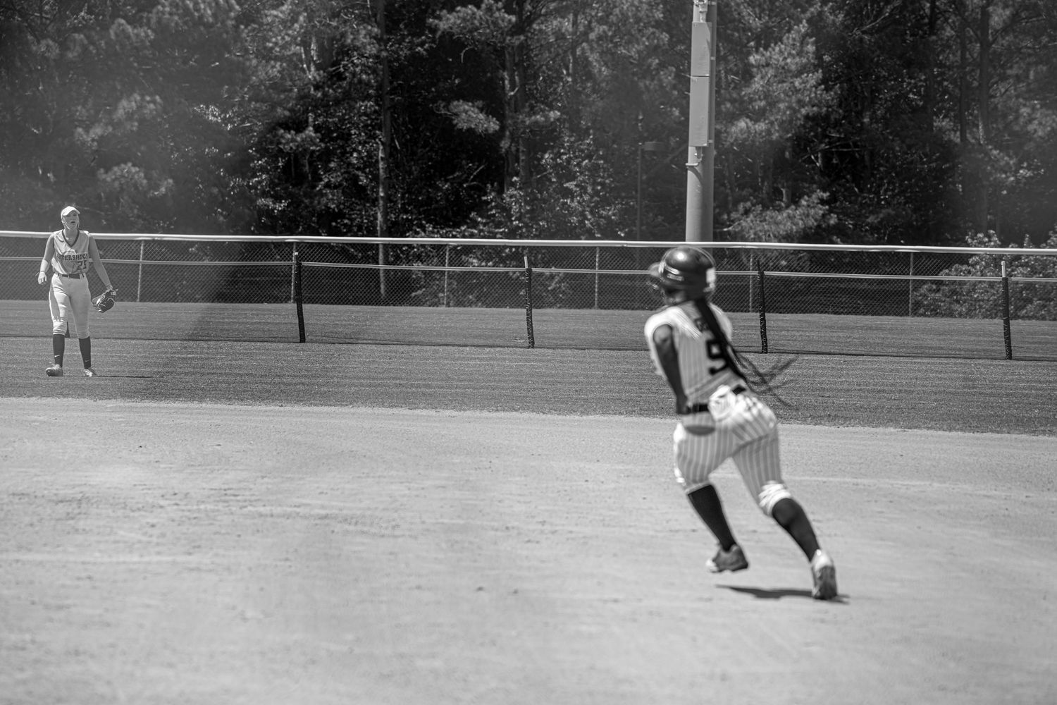 Black and white vintage photo of baseball player running on field during game.