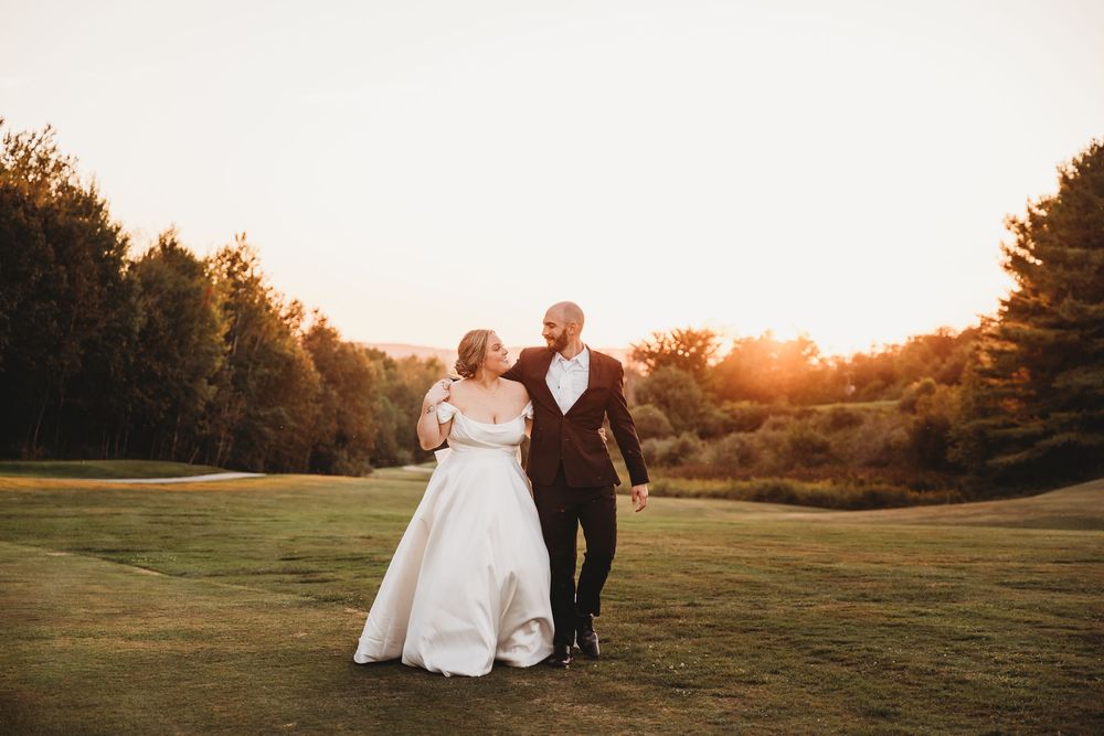Romantic sunset photo session in an expansive grassy field with warm evening light.