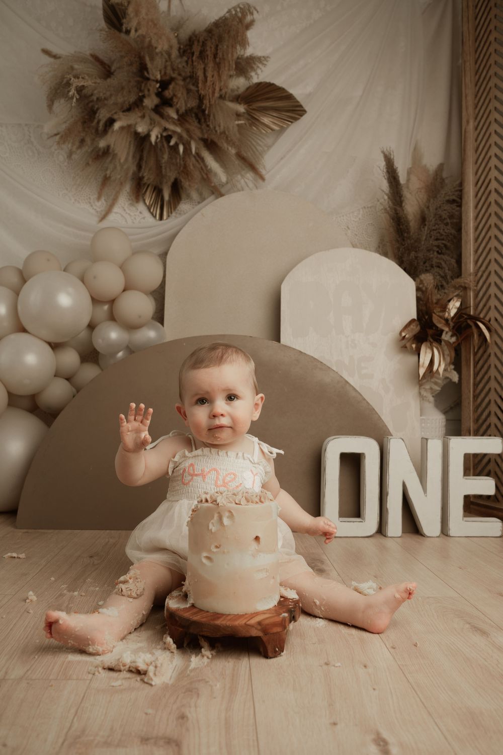 A baby's first birthday cake smash photo session showing progression of messy cake eating on a white backdrop.