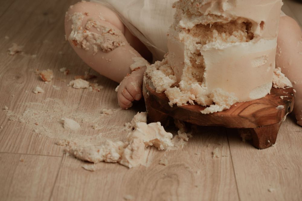 A sequence of hands mixing and kneading white dough on a wooden surface during bread making preparation.