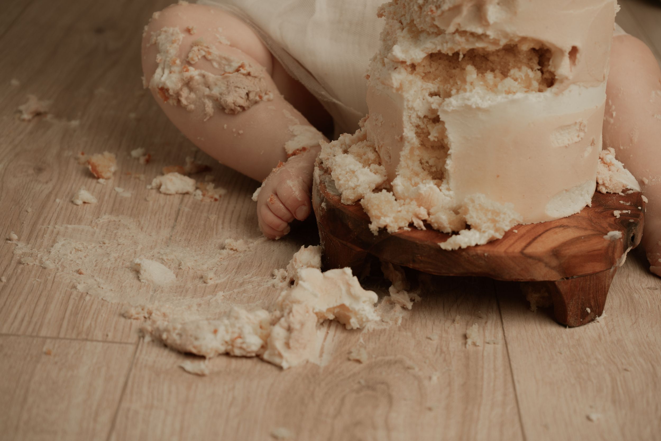 A sequence of hands mixing and kneading white dough on a wooden surface during bread making preparation.