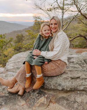 A sweet moment shared on a rocky mountain overlook wearing cozy winter attire.