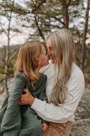 An intimate moment captured between two people on a mountain overlook wearing cozy sweaters.