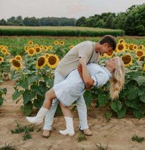 A romantic moment captured between a couple in a sunflower field.