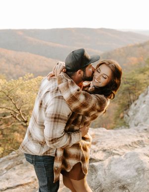 An intimate moment captured against a backdrop of autumn mountains and golden sunlight.