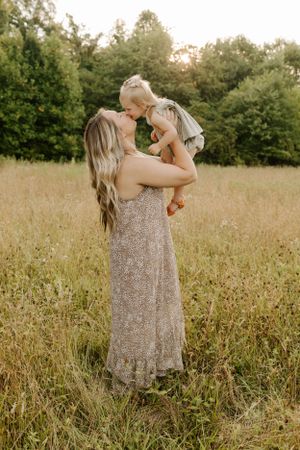 Mother and child sharing a joyful moment in a golden summer field.