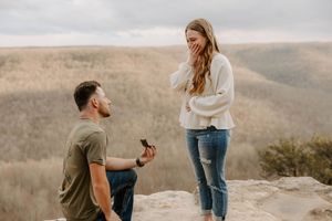 Marriage proposal moment captured on scenic mountain overlook.