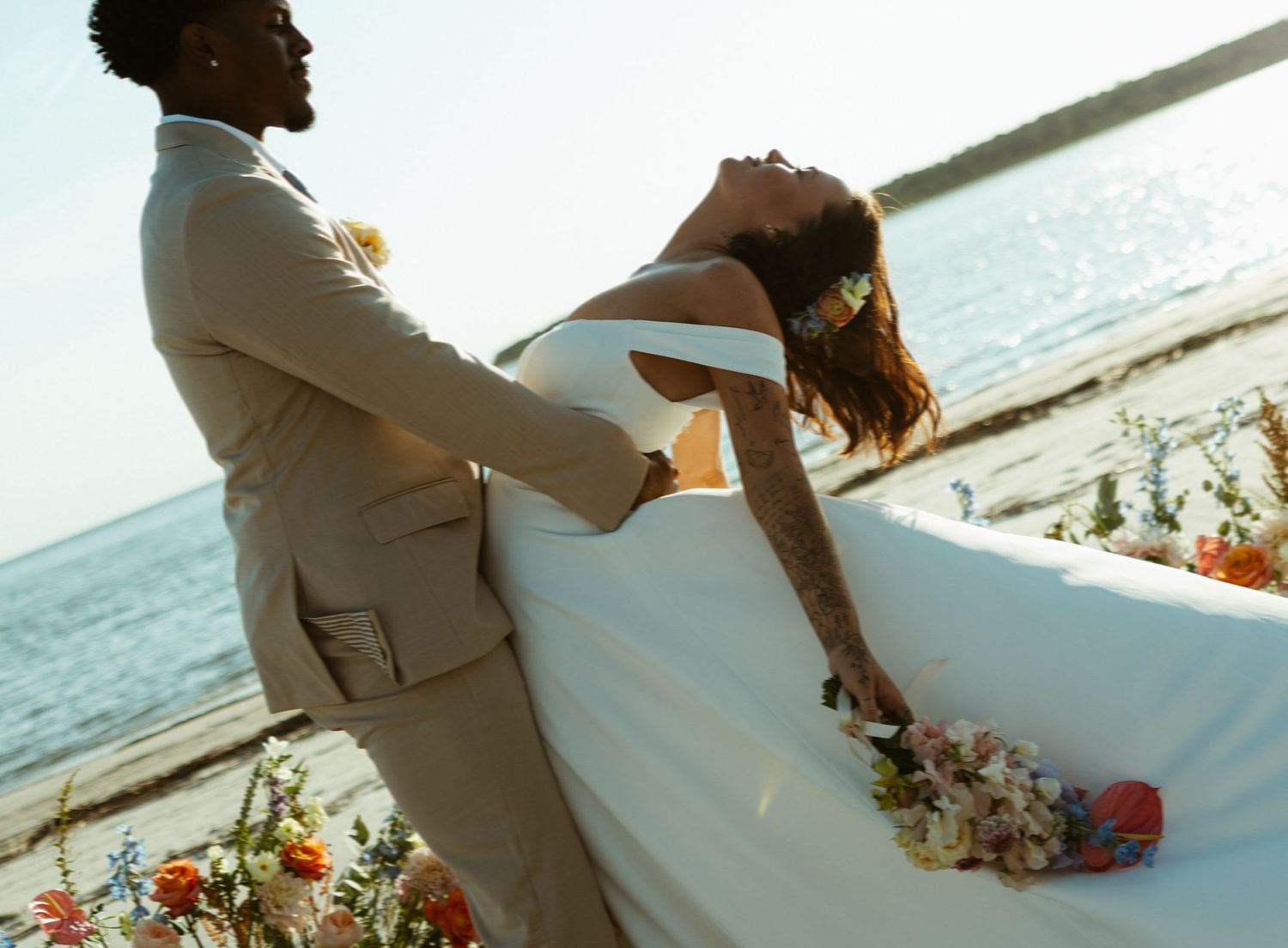 A romantic couple in wedding attire share an intimate moment with their faces close together.