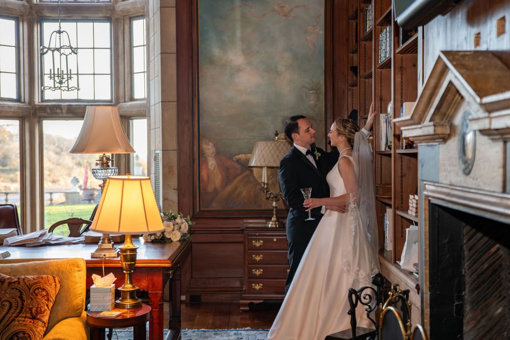Elegant indoor wedding venue with warm lighting, large windows, and vintage-style decor.