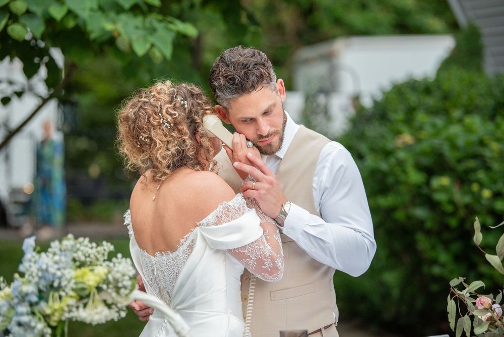 Wedding couple sharing intimate moment in lush garden setting with white flowers.