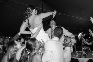Black and white photo of celebratory moment during wedding reception dance party.