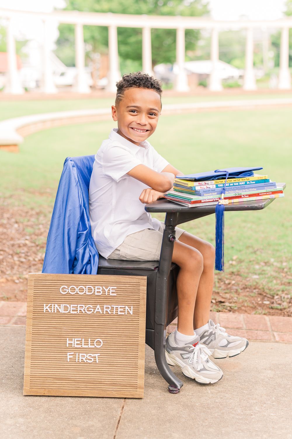 Kindergarten graduate at a desk with books, Newnan, GA
