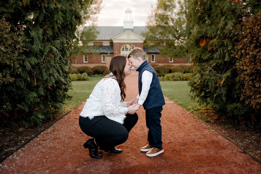 A couple shares romantic moments on a tree-lined brick pathway during an autumn photo session.