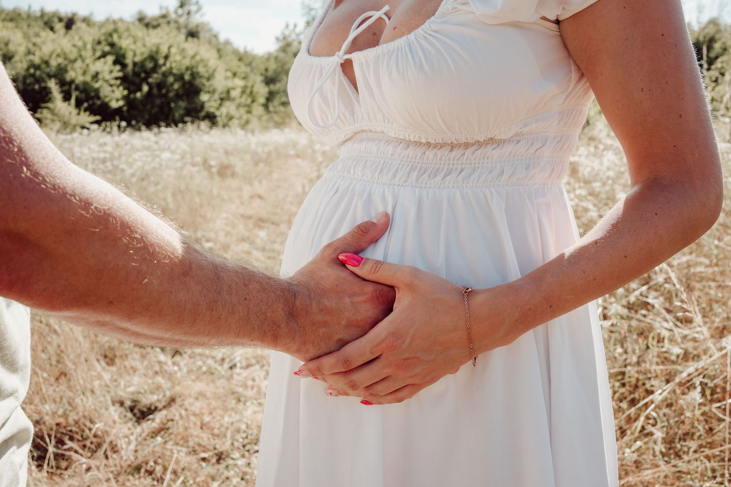 Koppel met zwangere vrouw die in een veldbaan wandelen