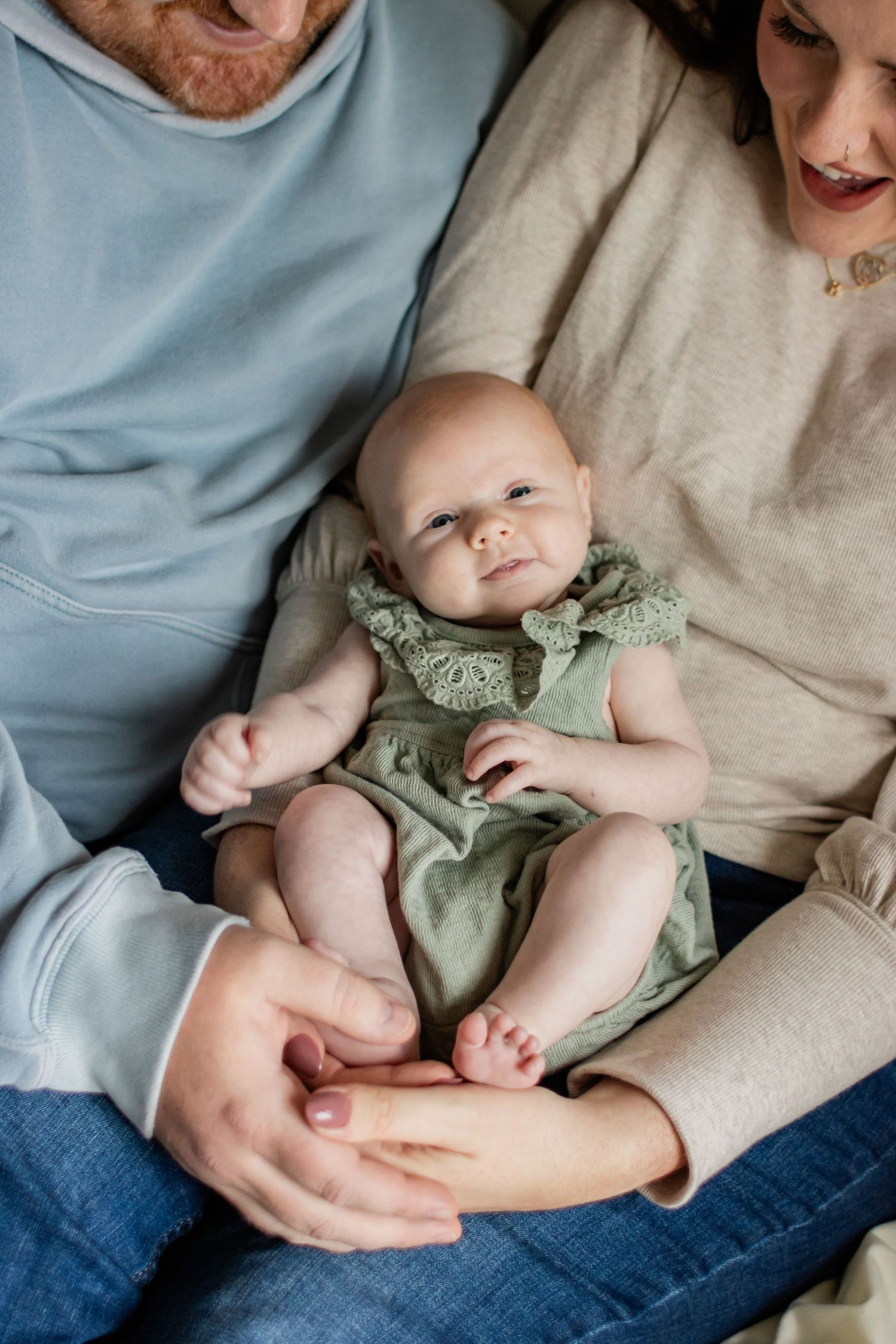 A baby girl smiling up at the camera.