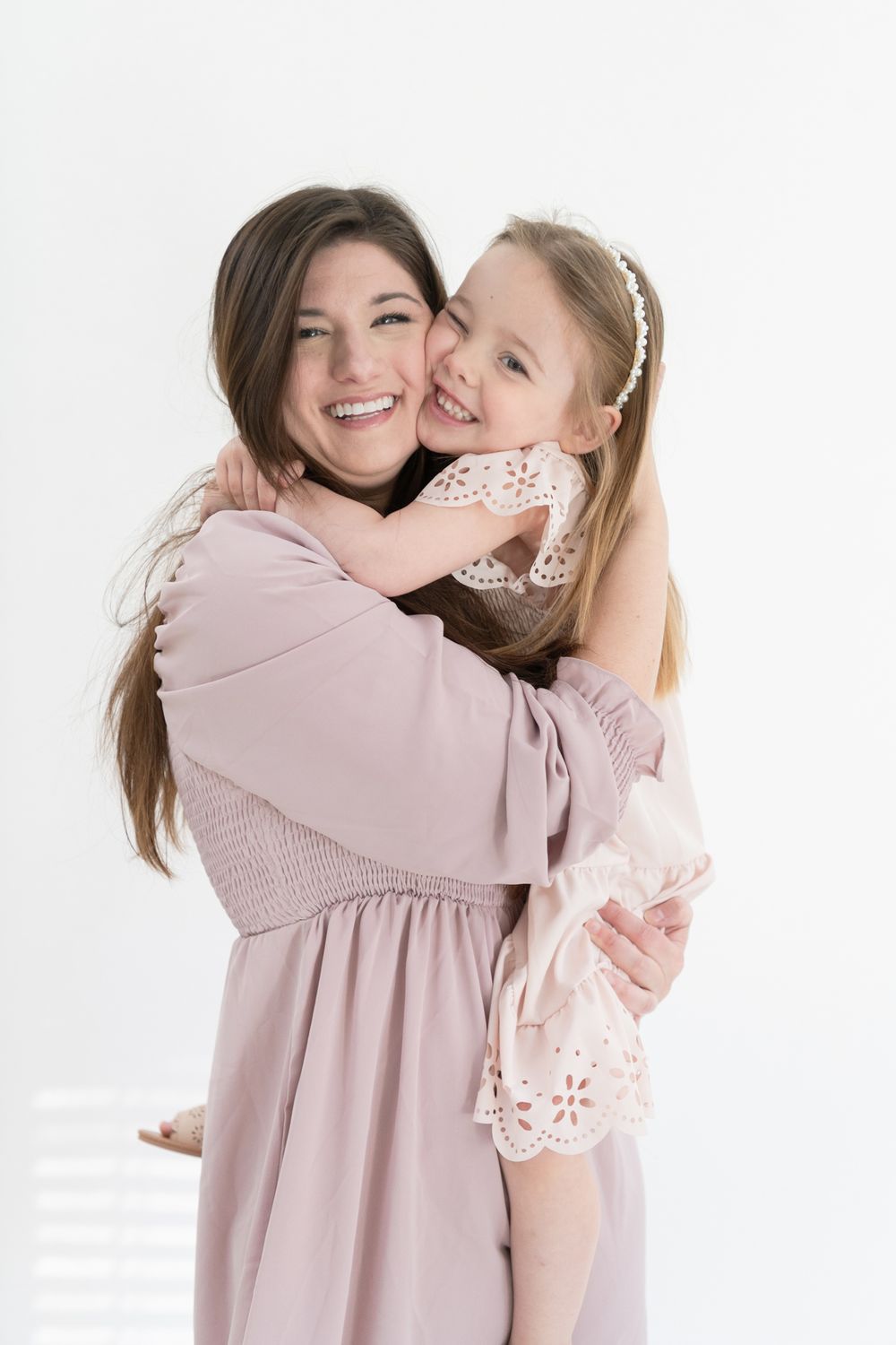 Studio portrait showing joyful embrace against white background.