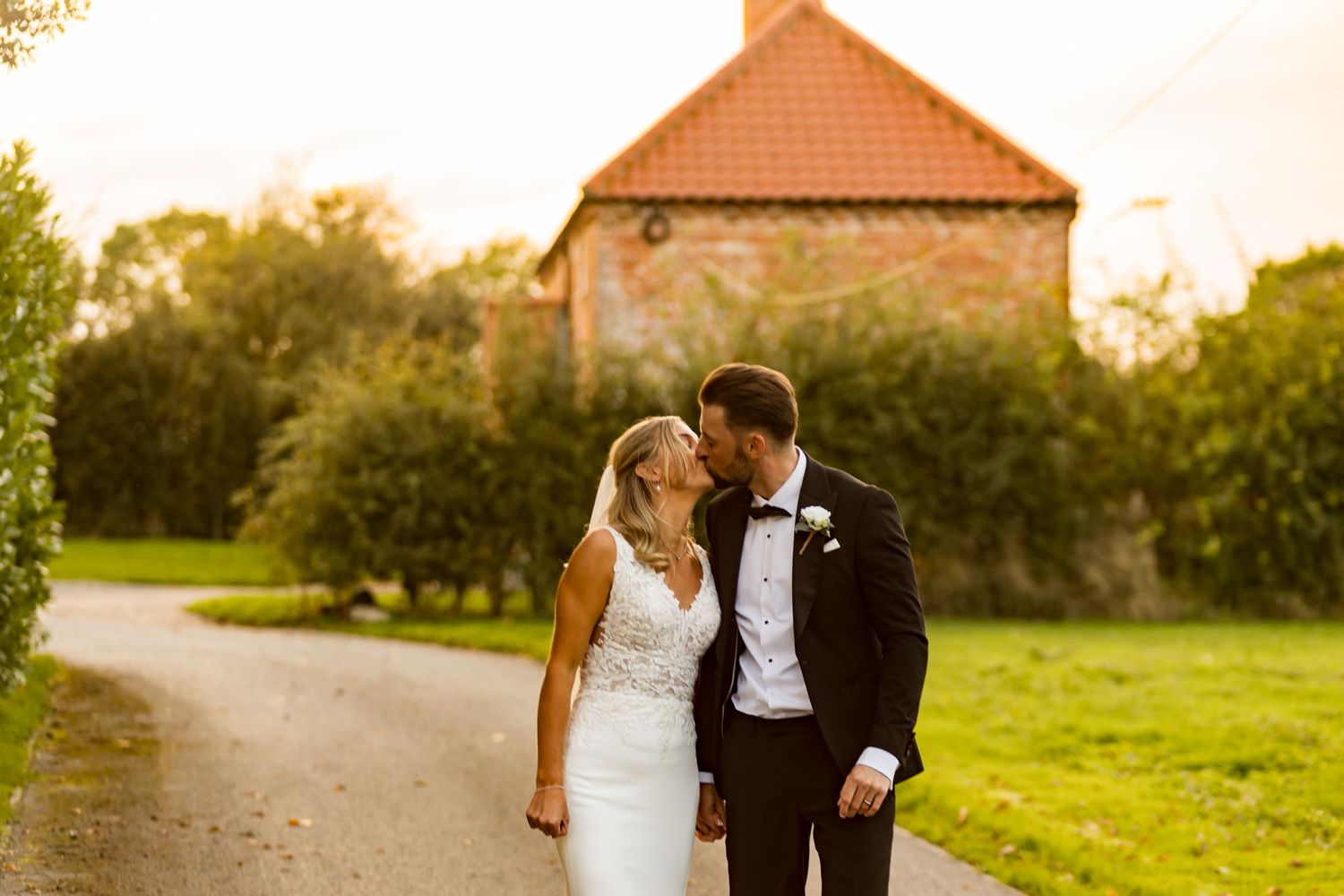 Romantic golden hour wedding photography session in a lush garden setting with warm sunlight filtering through trees.