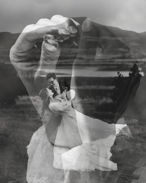 Black and white double exposure wedding photo of couple embracing, overlaid with hands forming a heart shape.