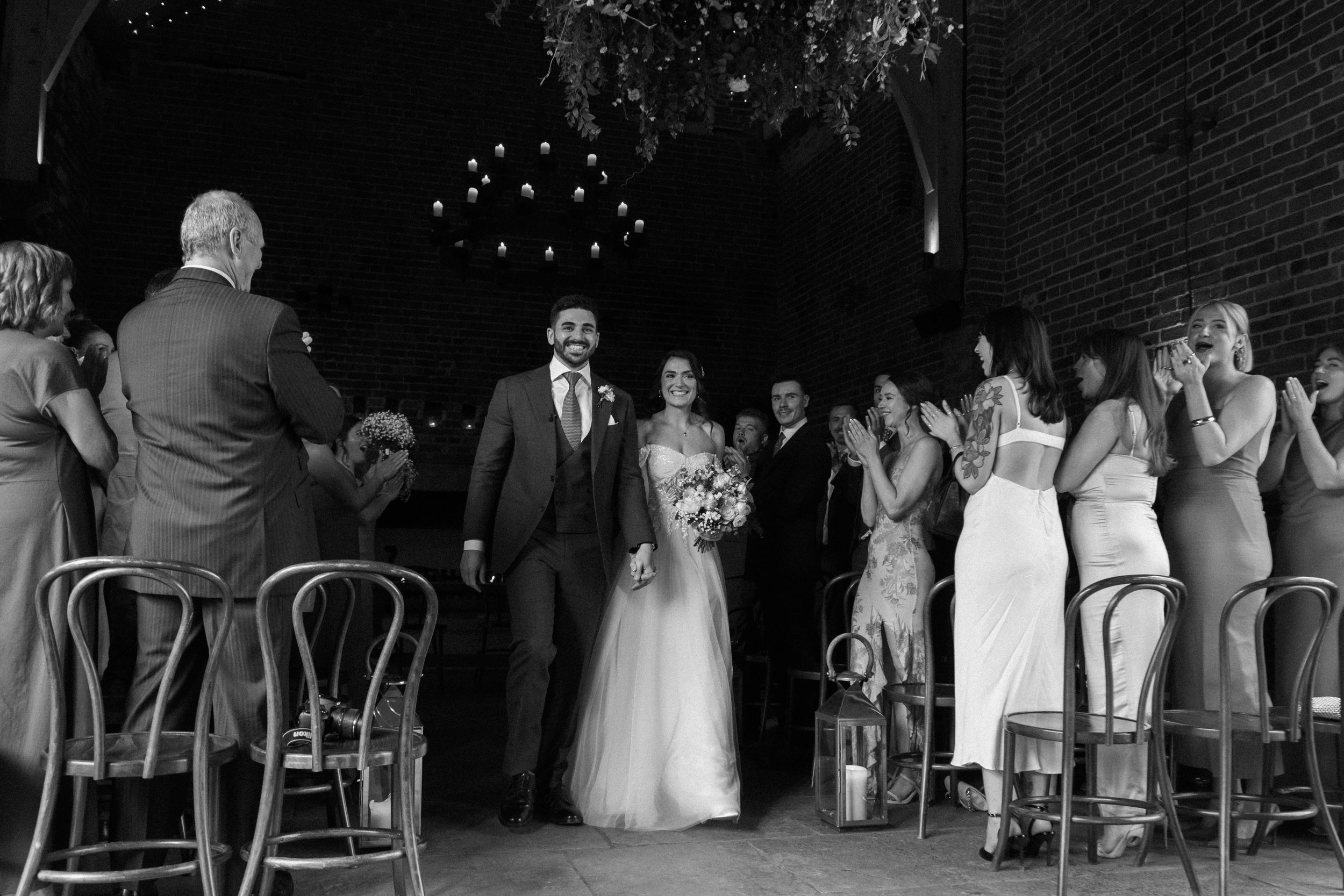 Bride and groom ceremony reccesional back down the aisle after first kiss at Cripps Grangefields Barn wedding venue
