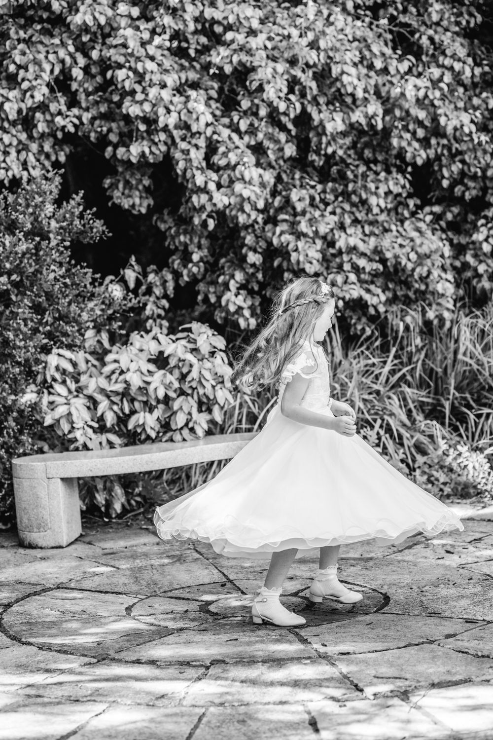Natural black and white First Communion photoshoot of a girl dancing, Ireland communion photographer.