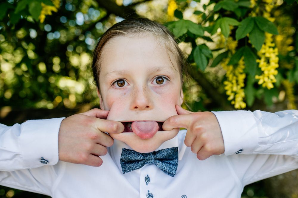Playful boy making a funny face with his tongue out, First Communion photoshoot with soft natural light, Roscommon.