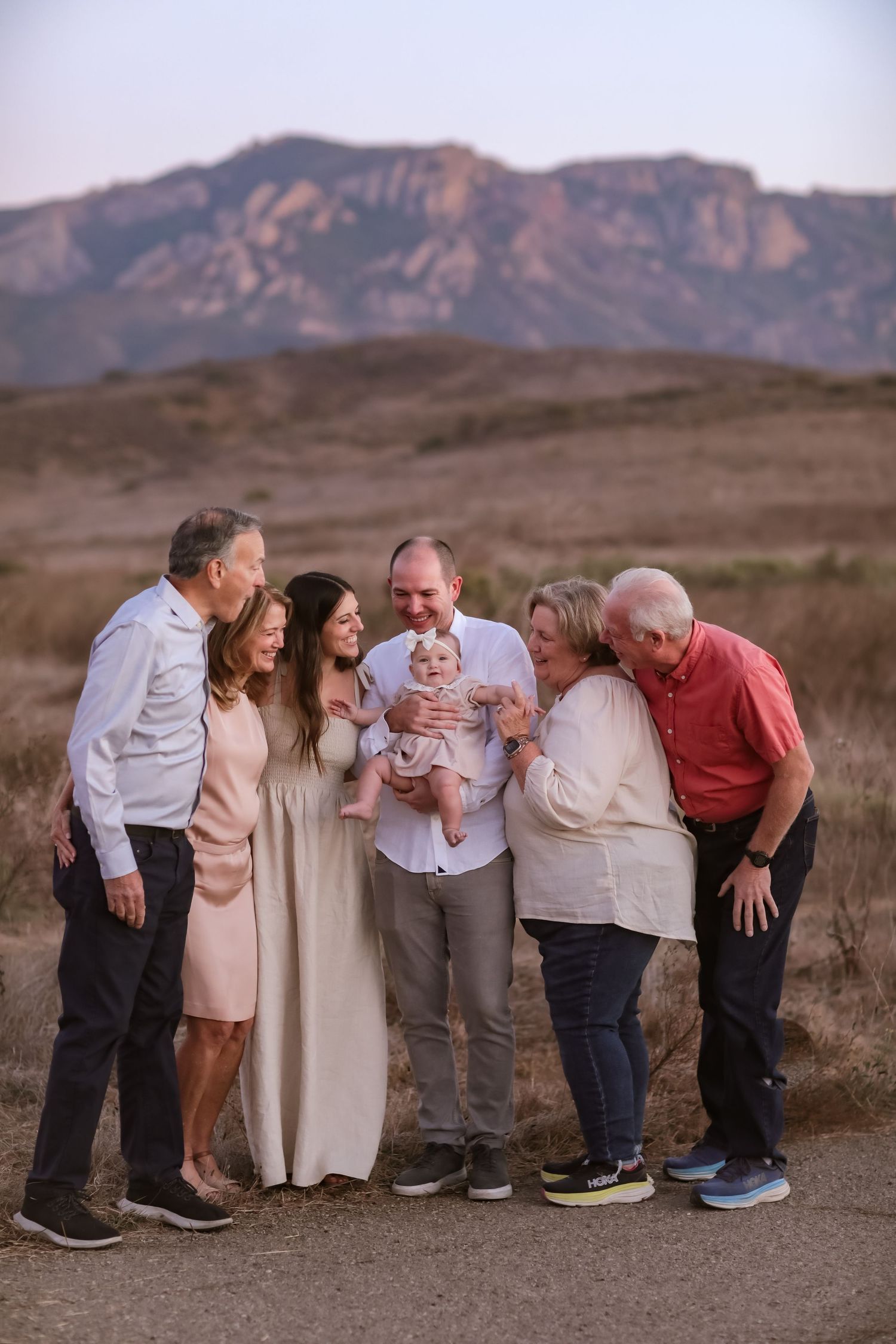 baby being held by father around both sets of parents with a mountain backdrop