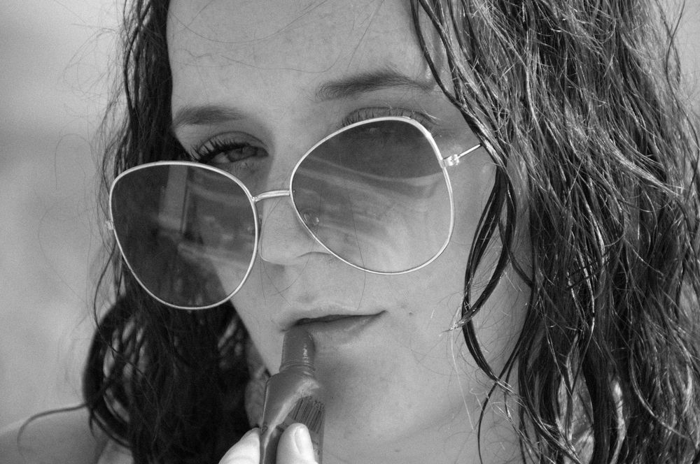 portrait of a girl applying lip balm, close up detail shot