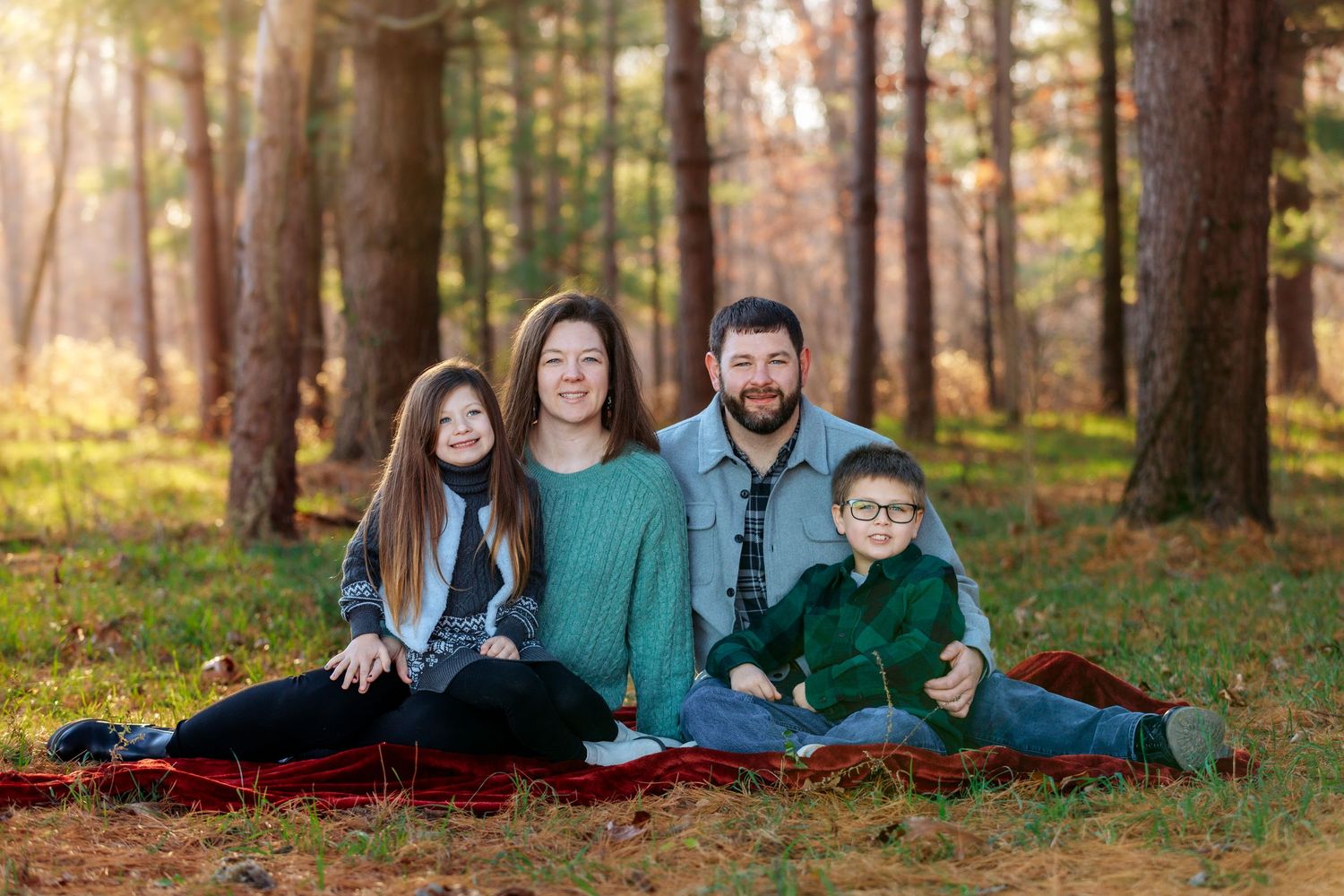 A large family, smiling together in the middle of the Neoga, Illinois countryside during the fall.