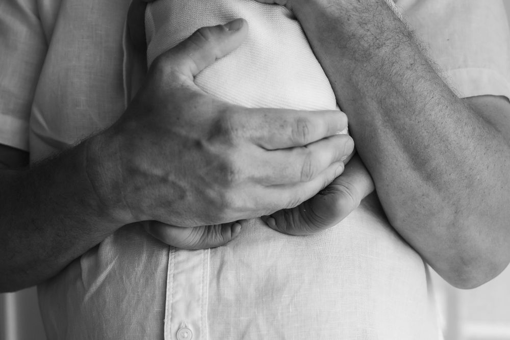 A series of intimate black and white close-up shots showing tender moments with a newborn baby.