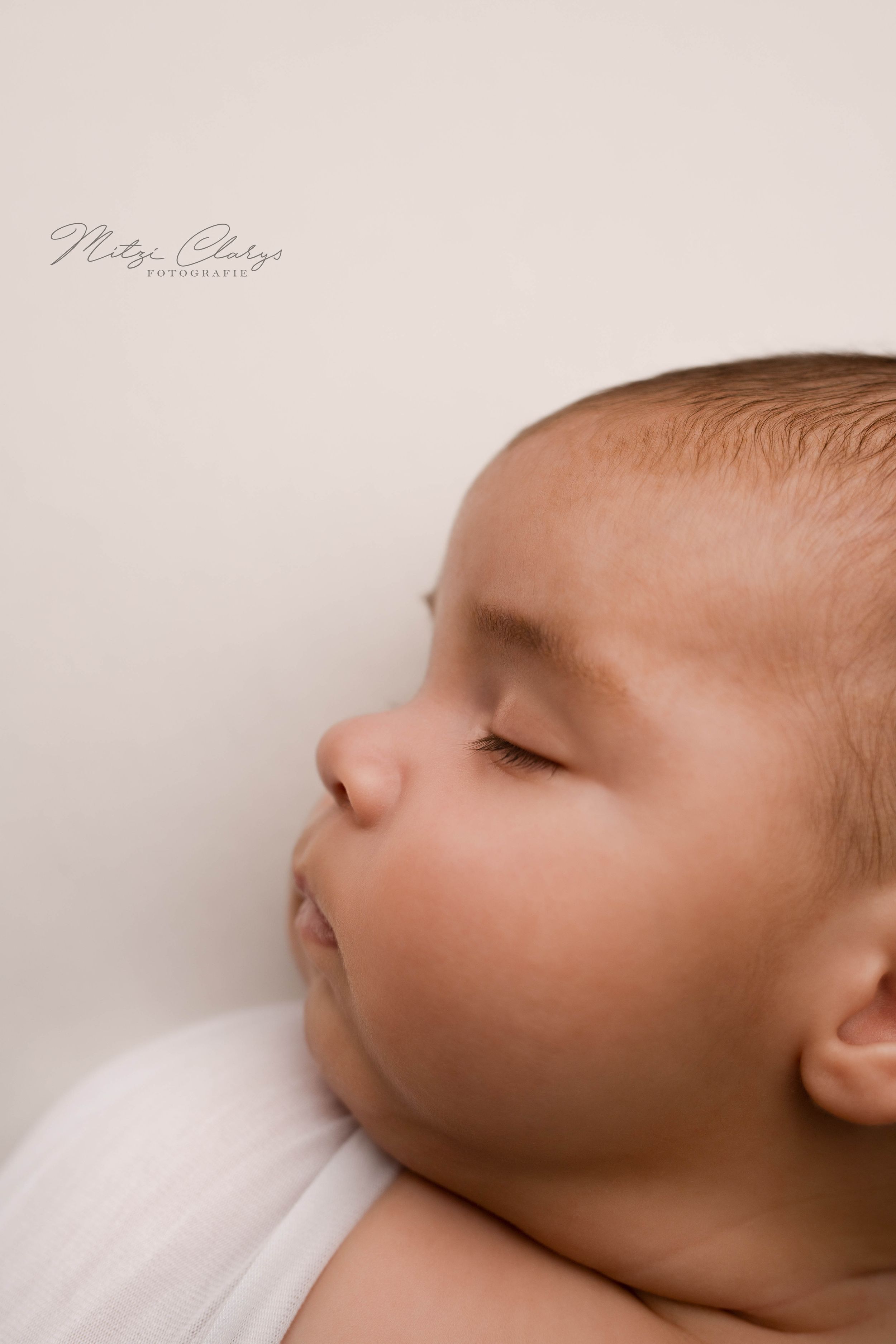 Close up portret van slapende newborn in witte wrap