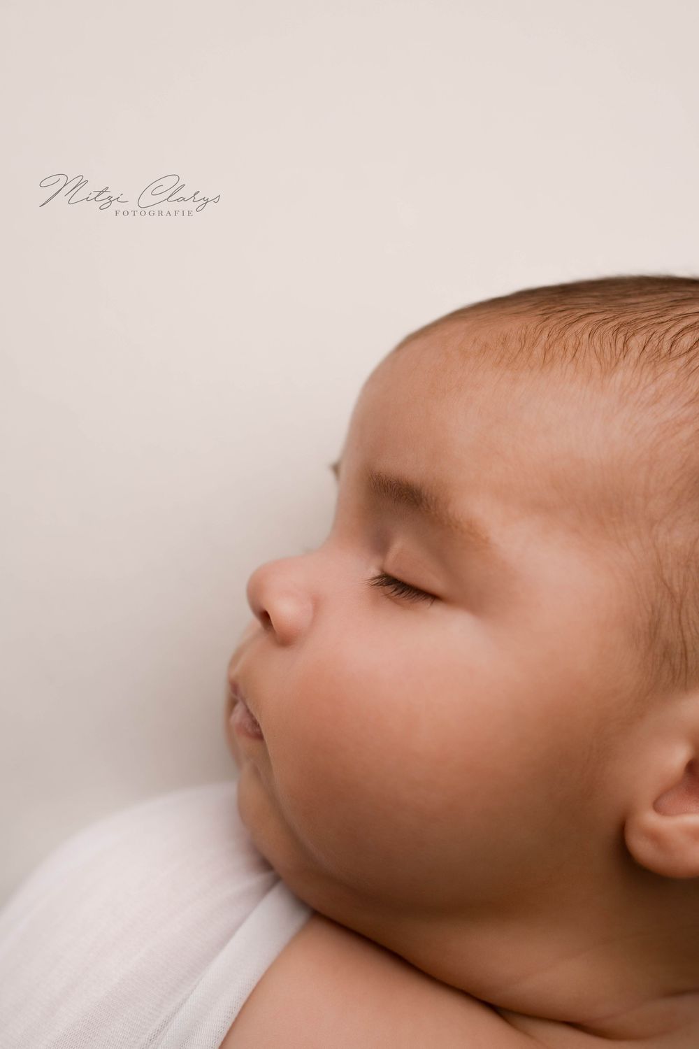 Close up portret van slapende newborn in witte wrap