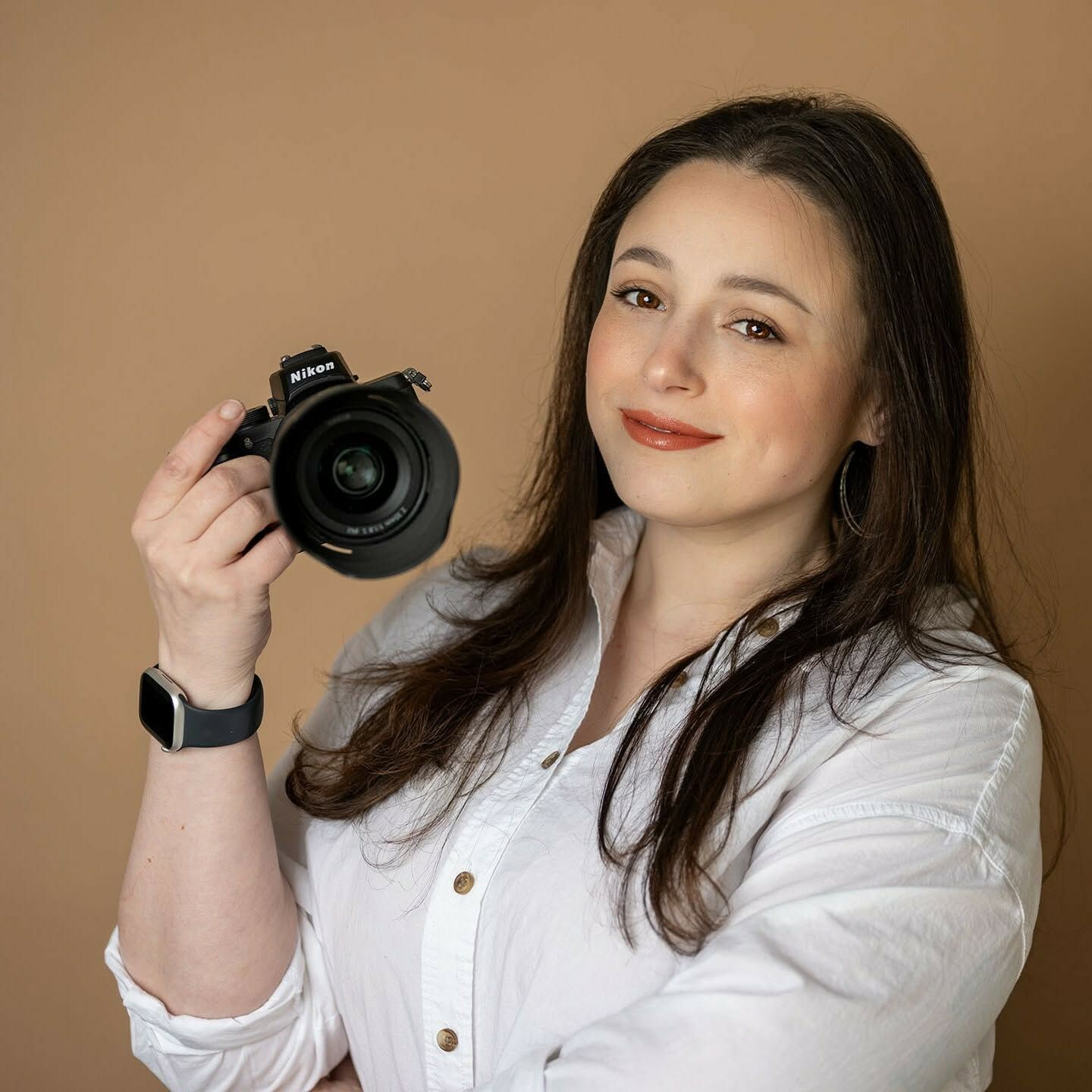 Girasoles Photography owner, Savannah Rivera, posing for a confident branding photo with her camera.